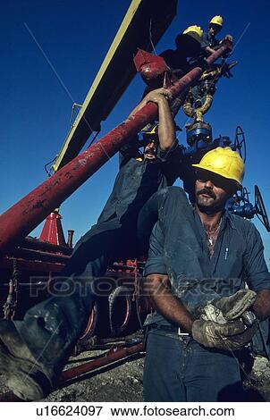 Stock Photo - Oilfield Workers, Wellhead Assembly Maintenance. Fotosearch