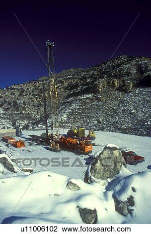 Stock Image - Onshore Oil Drilling Rig in Rugged Snow Covered Terrain. Fotosearch