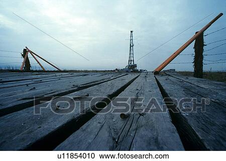 Onshore Oil Drilling Rig with Wooden Bridge in Foreground View Large Photo Image Stock Image - Onshore Oil Drilling Rig with Wooden Bridge in Foreground. Fotosearch