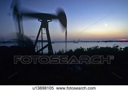 Stock Photography - Pump Jack with Houston Ship Channel and Fred Hartman Bridge in Background. Fotosearch