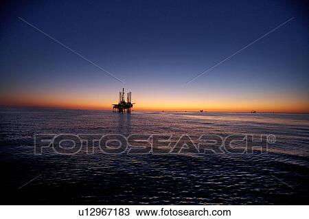 Stock Image - Silhouete of Offshore Oil Drilling Rig at Sunset. Fotosearch