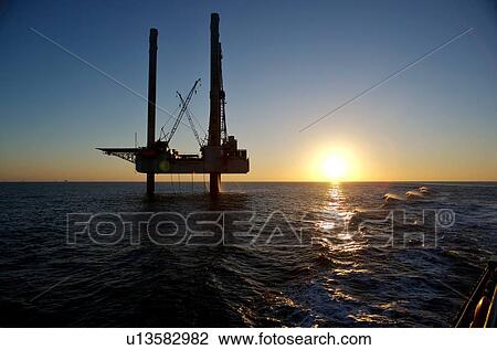 Stock Image - Silhouete of Offshore Oil Drilling Rig at Sunset. Fotosearch