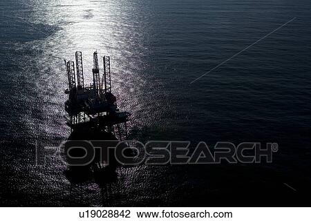 Stock Image - Silhouete of Offshore Oil Drilling Rig at Sunset. Fotosearch