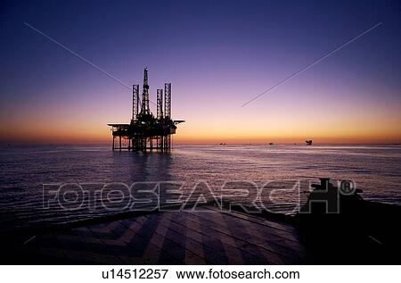 Stock Photo - Silhouete View from Supply Boat of Offshore Oil Drilling Rig at Sunset. Fotosearch