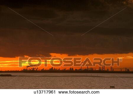 Stock Image - Silhouette of Oil Refinery at Sunset. Fotosearch