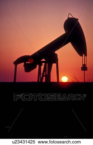 Stock Photography - Silhouette of Pump Jack Operating at Sunset. Fotosearch