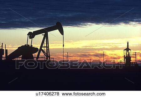 Stock Photo - Silhouettes of Two Pumps Jack Operating at Sunset. Fotosearch