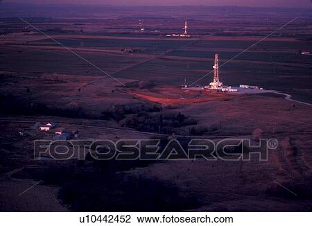 Two Onshore Oil Drilling Rigs in Farmland at Sunset View Large Photo Image Stock Image - Two Onshore Oil Drilling Rigs in Farmland at Sunset. Fotosearch