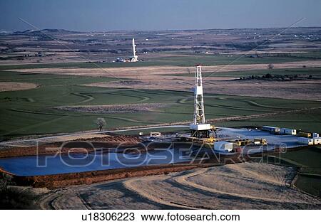 Stock Image - Two Onshore Oil Drilling Rigs in Farmland. Fotosearch