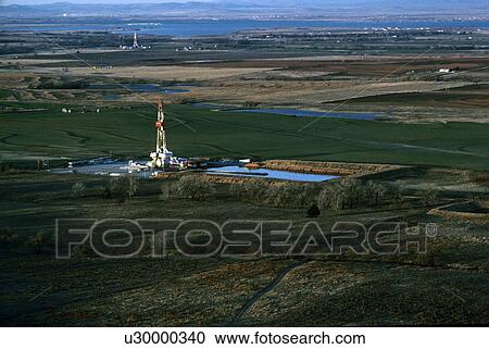 Stock Image - Two Onshore Oil Drilling Rigs in Farmland. Fotosearch