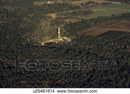 Picture - Two Onshore Oil Drilling Rigs in Wooded Area. Fotosearch