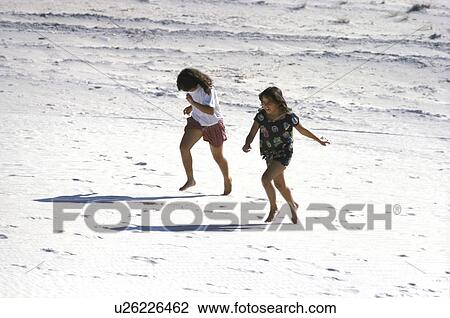 Stock Image - beach, two, sand, running, girls, portrait. Fotosearch