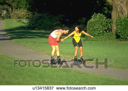 Stock Photo - gate, sport, golden, rollerblading, nature, couple. Fotosearch
