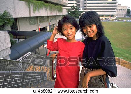 Stock Image - singapore, teenagers, smiling, buildings, people. Fotosearch