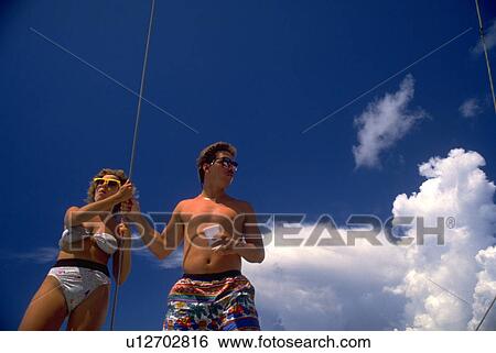 Stock Photograph - sunset, catamaran, cruise, ocean, cruising, couple. Fotosearch