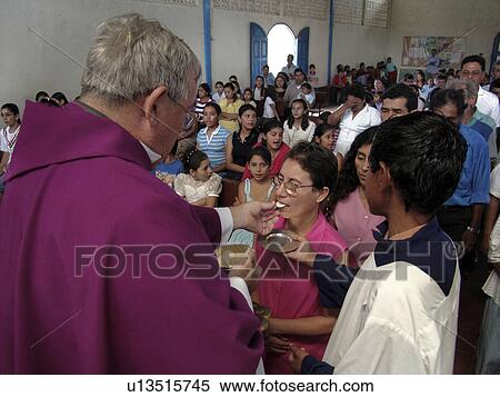 Stock Photography - giving, person, priest, catholic, nicaragua, people. Fotosearch