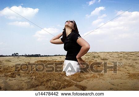 Stock Image - sand, released, buried, female, woman, model. Fotosearch