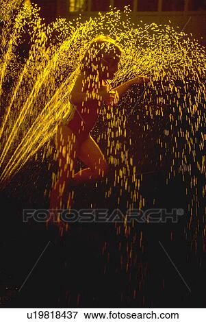 Stock Photo - summer, kid, sunset, sprinkler, lawn, child. Fotosearch