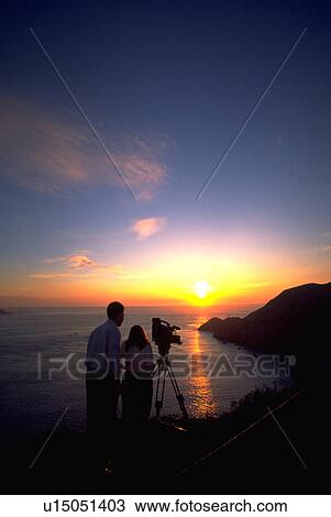 sunset, couple, photograph, taking, sun, water View Large Photo Image Stock Image - sunset, couple, photograph, taking, sun, water. Fotosearch