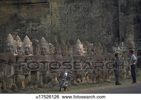 Stock Photograph - angkor, buddhas, cop, motorcycle, row, carved. Fotosearch