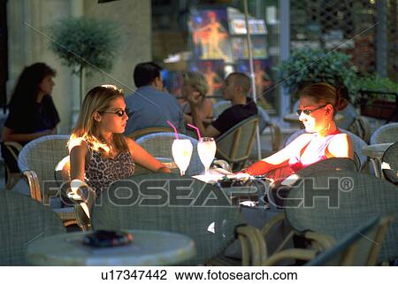 Stock Image - cafe, two, outdoor, drinks, females, women. Fotosearch