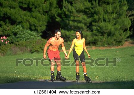 Picture - holding, fitness, skaters, nature, sport, couple. Fotosearch