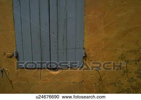Stock Image - stone, pale, deepyellow, shutters, blue, tree. Fotosearch