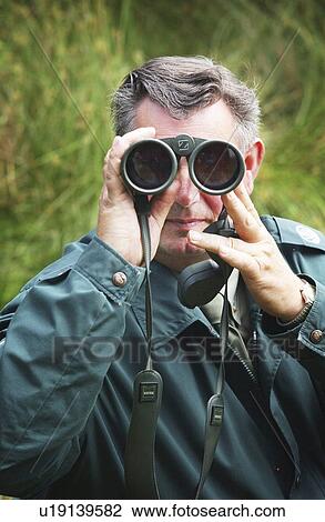 Stock Image - telescope, binoculars, watching, male, nature. Fotosearch