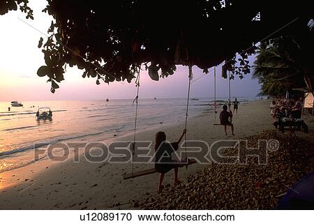 Stock Image - tree, boats, swings, girl, beach. Fotosearch
