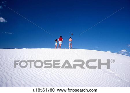 Stock Image - white, flying, dune, sand, kites, people. Fotosearch
