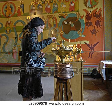 Stock Photo - candles, icon, lighting, russia, person, people. Fotosearch