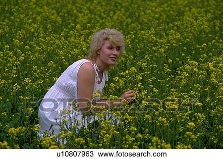 Stock Image - flowers, blonde, field, female, woman, beautiful. Fotosearch