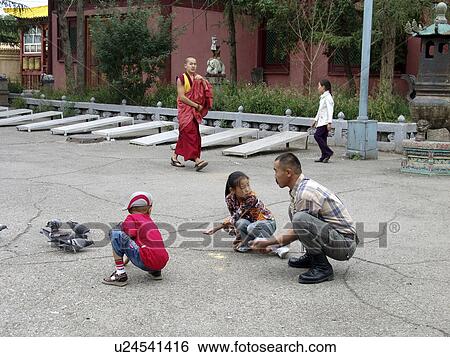 Stock Photograph - gandan, person, pigeons, feeding, mongolia, people. Fotosearch
