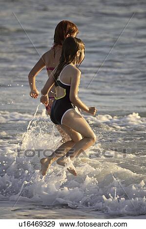 beach, young, surf, enjoying, girls, two View Large Photo Image Stock Photo - beach, young, surf, enjoying, girls, two. Fotosearch