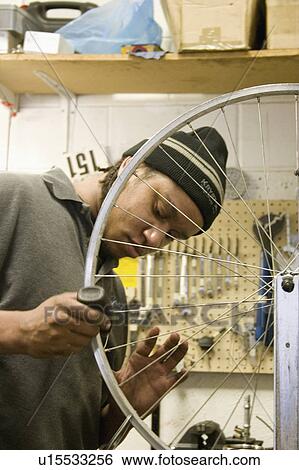 Stock Photograph - express, repairing, youth, wheel, bicycle, worker. Fotosearch