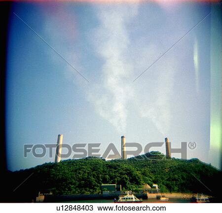 Stock Image - green, coming, behind, chimneys, tall, pollution. Fotosearch