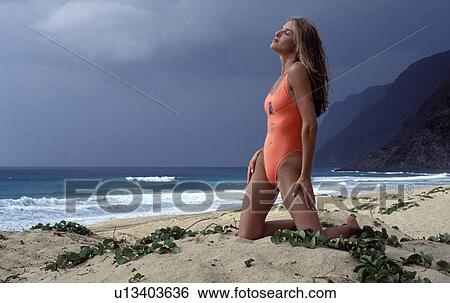 Stock Photograph - knees, ocean, storm, sand, model. Fotosearch