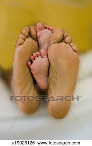 Stock Photograph - new, feet, tiny, sons, baby, fathers. Fotosearch