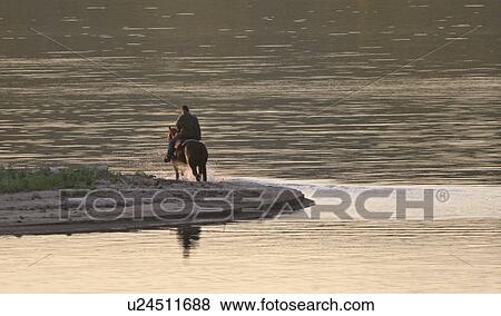 Stock Photo - saskatchewan, rider, scenic, lake, shore, horse. Fotosearch