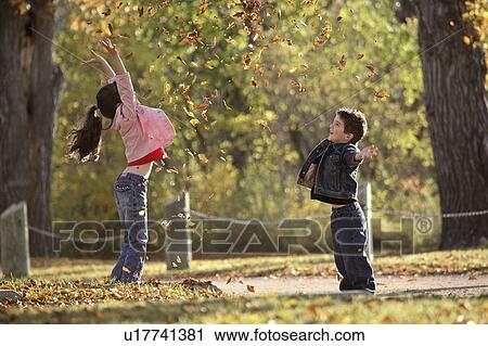 Stock Image - scenic, tossing, leaves, autumn, up, siblings. Fotosearch