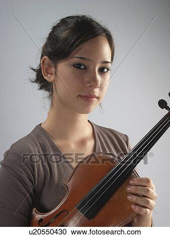 Stock Image - studio, female, violin, holding, violinist, young. Fotosearch