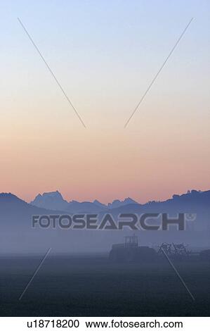 Stock Image - background, field, mountains, cascade, sunrise, tractor. Fotosearch