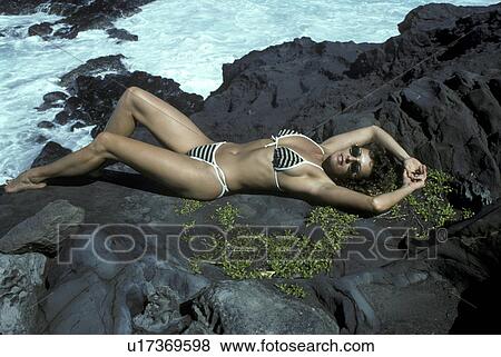 Stock Photo - bikini, rock, back, lying, model. Fotosearch