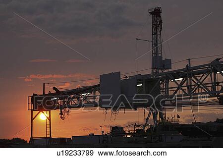 Stock Photo - drilling, setting, oil, mission, behind, sun. Fotosearch