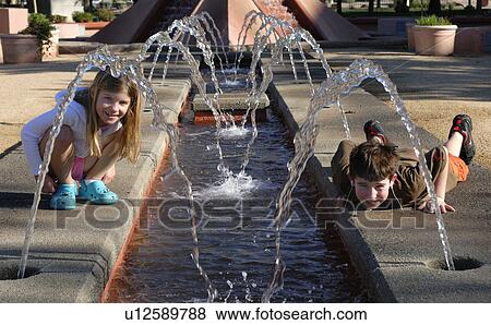 Stock Photo - fountain, sister, public, water, looking, brother. Fotosearch