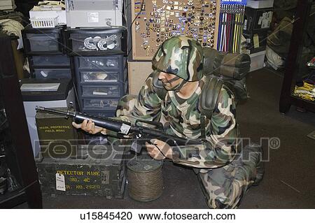 Stock Image - holding, soldier, uniform, camouflage, dressed, mannequin. Fotosearch