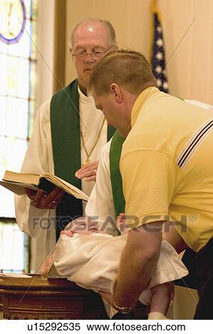 Stock Photography - holding, vining, baptism, minister, father. Fotosearch