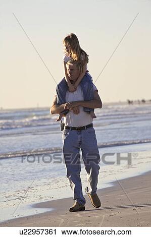 Stock Image - scenic, carrying, beach, water, daughter, father. Fotosearch
