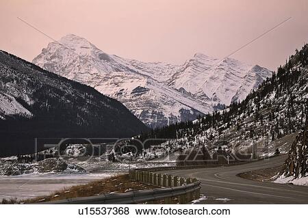 Stock Photo - snow, mountains, highway, road, winter, rocky. Fotosearch