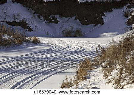 Stock Image - scenic, frozen, skidoo, snow, river, tracks. Fotosearch